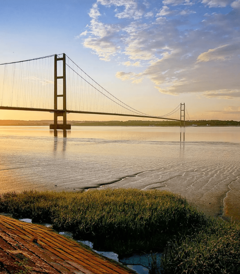 Living room with gray sofa and large windows with white curtains